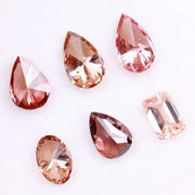 Six lab grown fancy colored diamonds in pink, blush, champagne and deep rose tones featuring pear, oval and emerald cuts displayed on a white background for fine jewelry design.