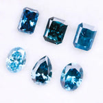 Six lab grown blue diamonds in emerald, oval and pear cuts displaying fancy deep ocean blue color arranged on white background for custom engagement ring and fine jewelry making.