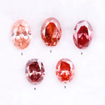 Five oval cut pink lab grown diamonds displayed on a white background, ranging in color from light blush pink to deep vivid rose and red tones, shown for color comparison and gemstone selection.