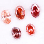 Five oval cut pink lab grown diamonds displayed on a white background, ranging in color from light blush pink to deep vivid rose and red tones, shown for color comparison and gemstone selection.