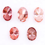 Five oval cut pink lab grown diamonds displayed on a white background, ranging in color from light blush pink to deep vivid rose and red tones, shown for color comparison and gemstone selection.