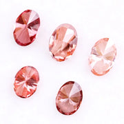 Five oval cut pink lab grown diamonds displayed on a white background, ranging in color from light blush pink to deep vivid rose and red tones, shown for color comparison and gemstone selection.