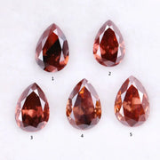 Five pear-shaped lab grown diamonds in fancy deep pinkish red color arranged on a white background, featuring brilliant faceting and teardrop cut for engagement rings and custom fine jewelry.