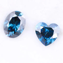 Oval and heart shaped fancy deep blue lab grown diamonds with brilliant faceting, showcasing vivid teal blue tones and VS clarity on a white background.