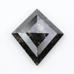 sharp kite cut rustic black diamond gemstone showcasing brilliant, highly reflective facets across a sleek triangular silhouette.