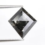 sharp kite cut rustic black diamond gemstone showcasing brilliant, highly reflective facets across a sleek triangular silhouette.