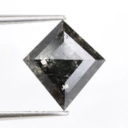 sharp kite cut rustic black diamond gemstone showcasing brilliant, highly reflective facets across a sleek triangular silhouette.