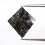 sharp kite cut rustic black diamond gemstone showcasing brilliant, highly reflective facets across a sleek triangular silhouette.