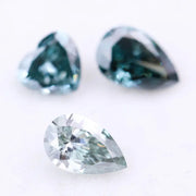 Three blue lab grown diamonds displayed on white background: pear cut light blue diamond (1), heart cut teal diamond (2), and deep blue pear shaped diamond (3), brilliant faceted loose stones for engagement ring or custom fine jewelry.