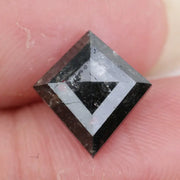 sharp kite cut rustic black diamond gemstone showcasing brilliant, highly reflective facets across a sleek triangular silhouette.