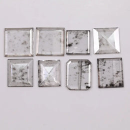 Square step-cut lab grown diamond with beveled edges and geometric faceting, loose ethical man made diamond for engagement ring or custom fine jewelry setting displayed on white background.