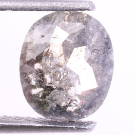 Oval-shaped diamond held between two silver prongs on a white background