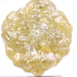 Raw diamond held by tweezers on a white background