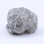 Close-up of rough diamond emphasizing natural sparkle and irregular, uncut crystal surfaces.