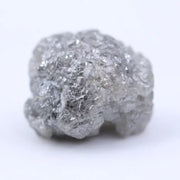 Close-up of rough diamond emphasizing natural sparkle and irregular, uncut crystal surfaces.