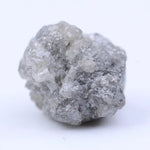 Close-up of rough diamond emphasizing natural sparkle and irregular, uncut crystal surfaces.