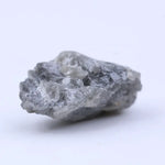 Natural diamond in raw form with subtle sparkle and rugged, organic shape.