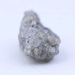 Natural diamond in raw form with subtle sparkle and rugged, organic shape.