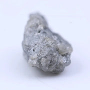 Natural diamond in raw form with subtle sparkle and rugged, organic shape.