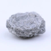 Natural black raw diamond embedded in rock with rough crystal structure and natural mineral texture