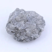 Natural black raw diamond embedded in rock with rough crystal structure and natural mineral texture