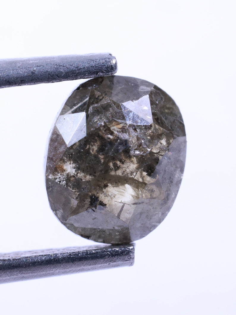 Diamond held between tweezers on a white background