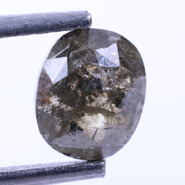 Diamond held between tweezers on a white background