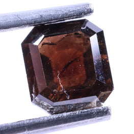 Brown diamond held by tweezers on a white background