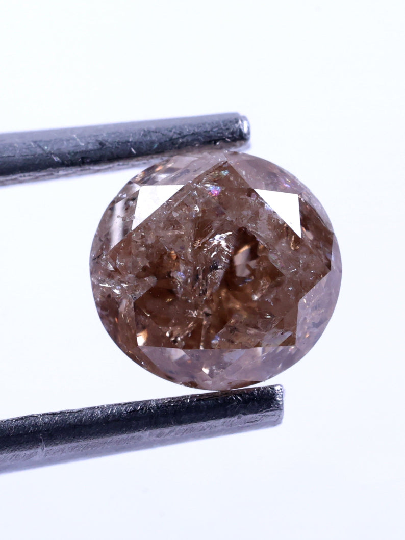 Brown diamond held by tweezers on a white background