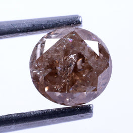 Brown diamond held by tweezers on a white background
