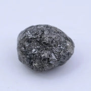 Close view of premium black diamond with bold dark sparkle and natural surface.