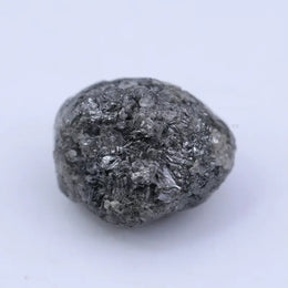 Close view of premium black diamond with bold dark sparkle and natural surface.