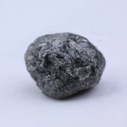 Close view of premium black diamond with bold dark sparkle and natural surface.