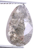 Teardrop-shaped diamond held between tweezers on a white background