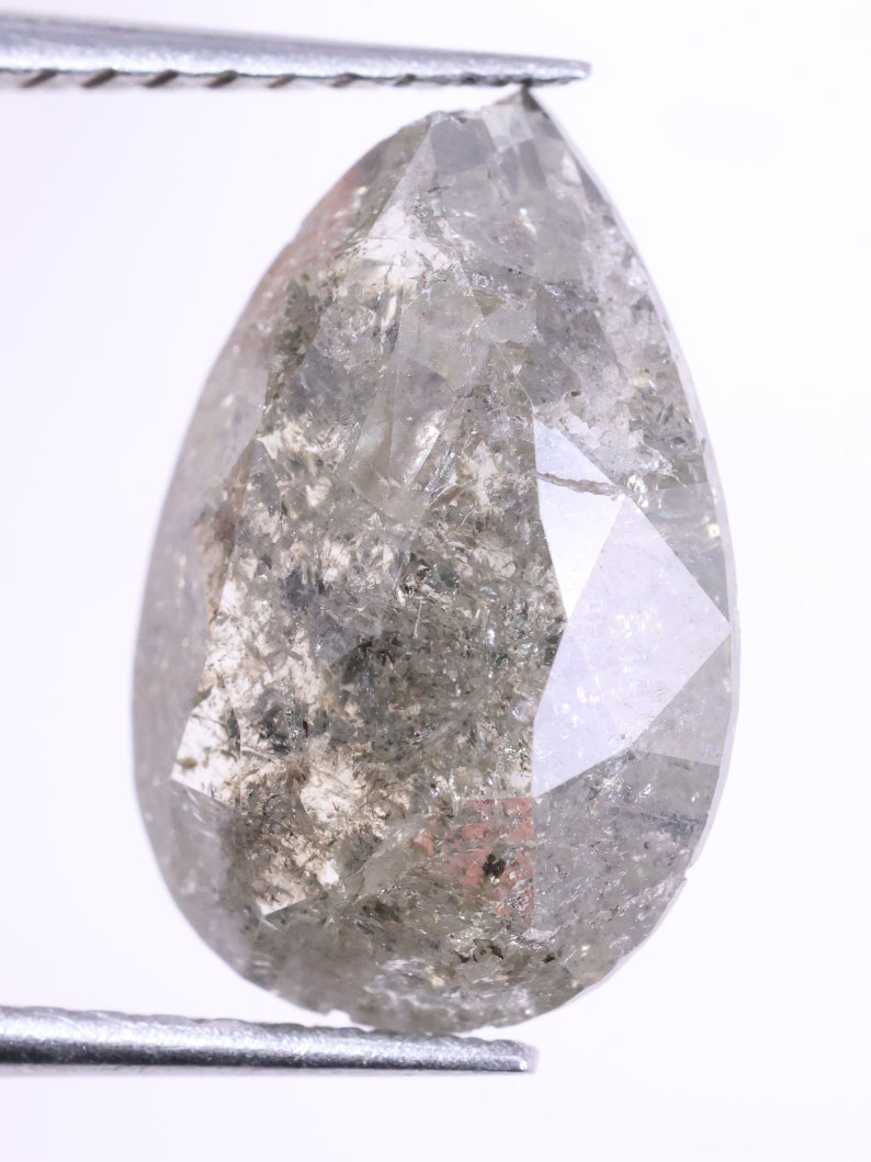 Teardrop-shaped diamond held between tweezers on a white background