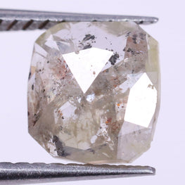 Diamond held between tweezers on a light purple background