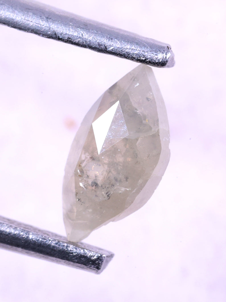 marquise-shaped diamond held between two silver tweezers on a light purple background