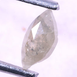 marquise-shaped diamond held between two silver tweezers on a light purple background