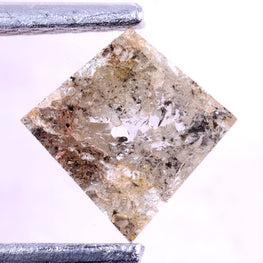 kite-cut diamond held between tweezers on a light background