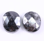 Two oval-shaped diamond with a black and gray pattern on a white background