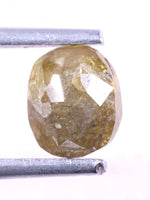 natural diamond held between two metal rods on a white background