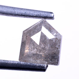 Bullet cut diamond held between tweezers on a white background