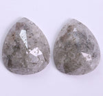 Two teardrop-shaped gray stones on a white background