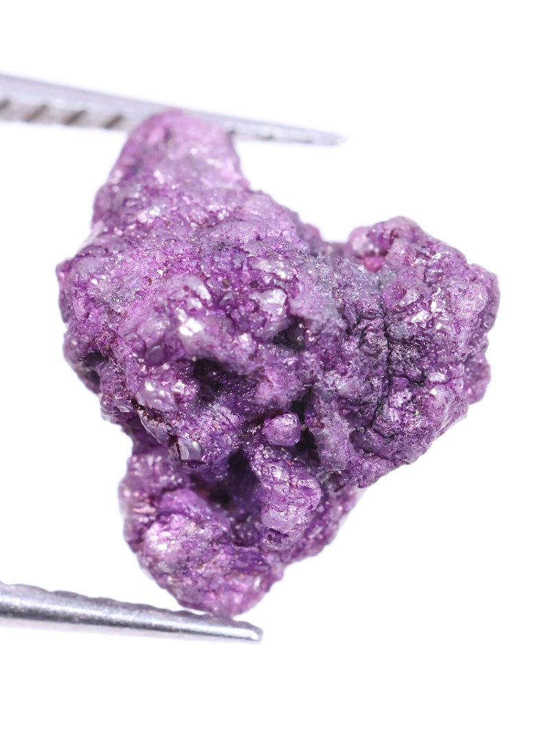 Purple diamond on tweezers against a white background