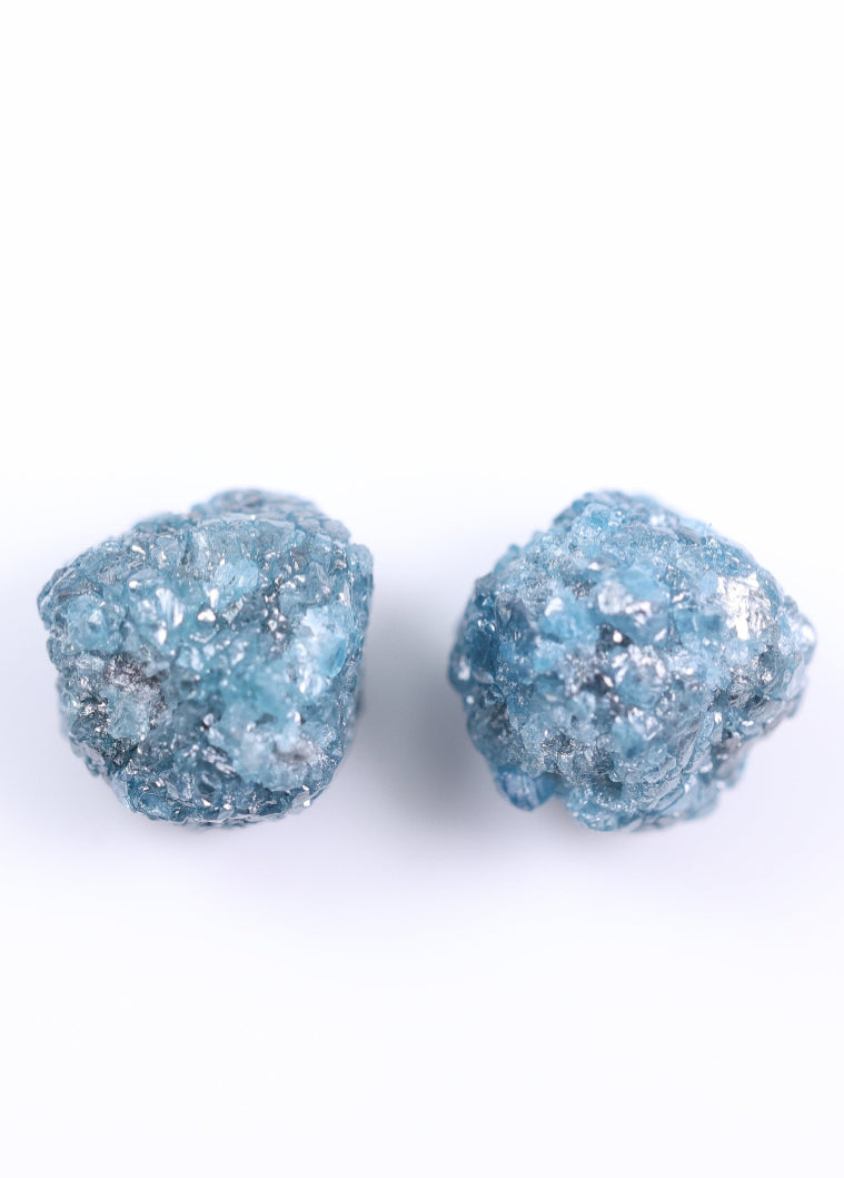 Pair of blue glittery stud earrings on a white background