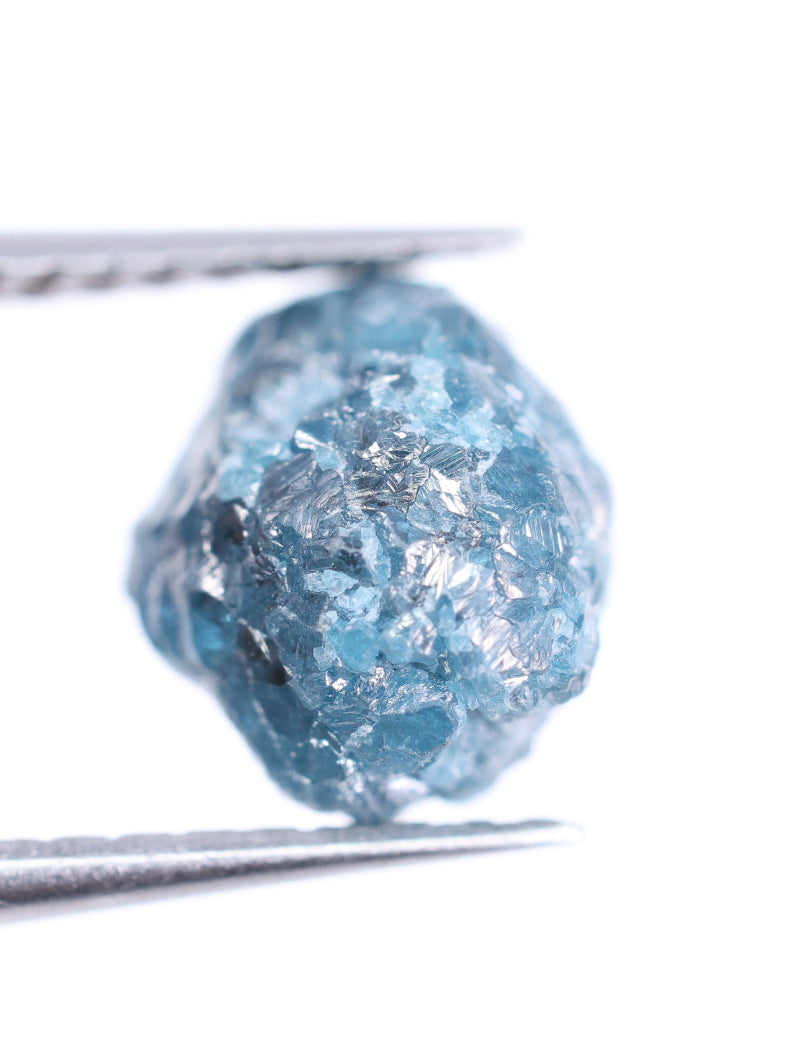blue rough diamond held by tweezers on a white background