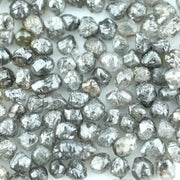 Mixed silver smoky raw uncut loose diamond crystals in natural grey and translucent white tones, rough earth-mined diamonds for jewelry making.