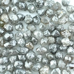 Mixed silver smoky raw uncut loose diamond crystals in natural grey and translucent white tones, rough earth-mined diamonds for jewelry making.