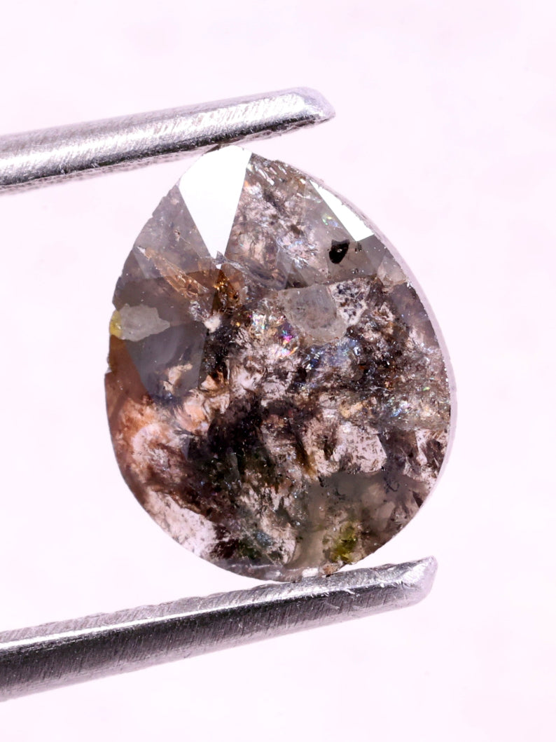 Brown natural diamond held by tweezers on a white background