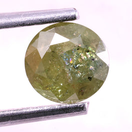 greenish yellow natural diamond held between tweezers on a white background